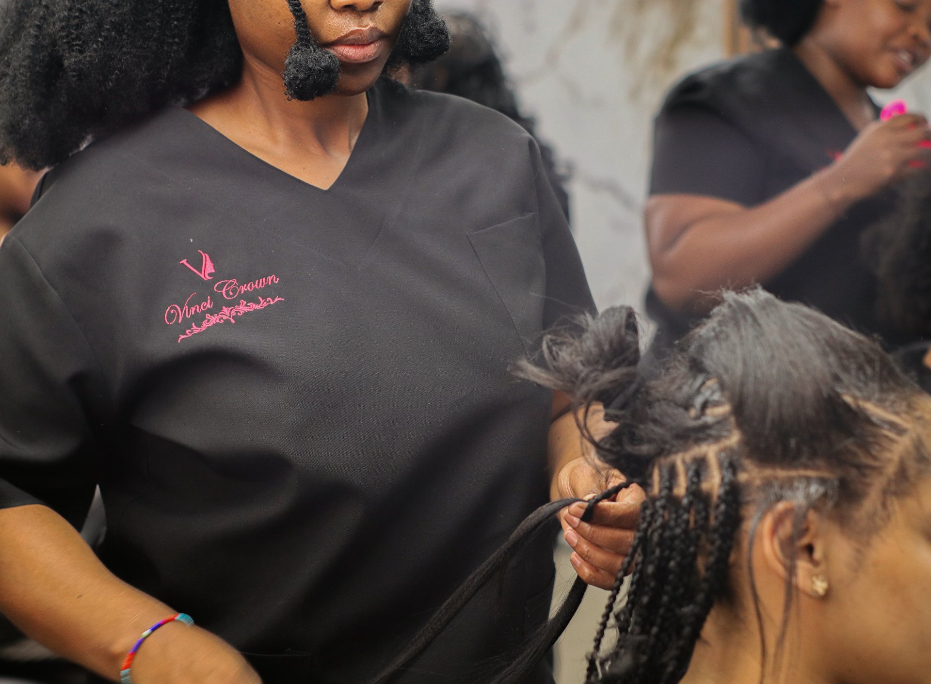 Vinci Crown stylist braiding a client's hair in the salon